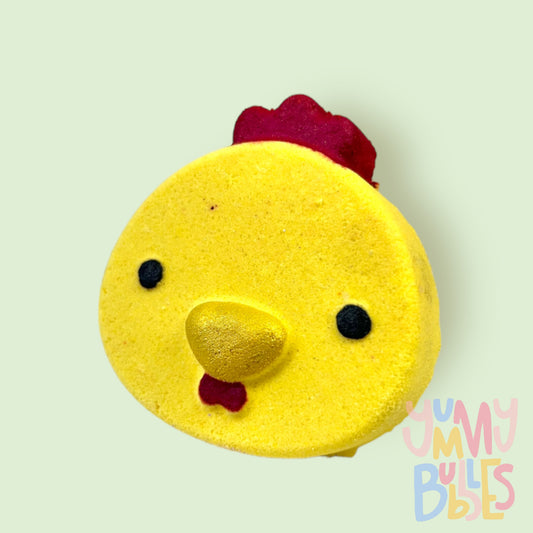 Yellow chick shaped bath bomb painted with red, gold, and black