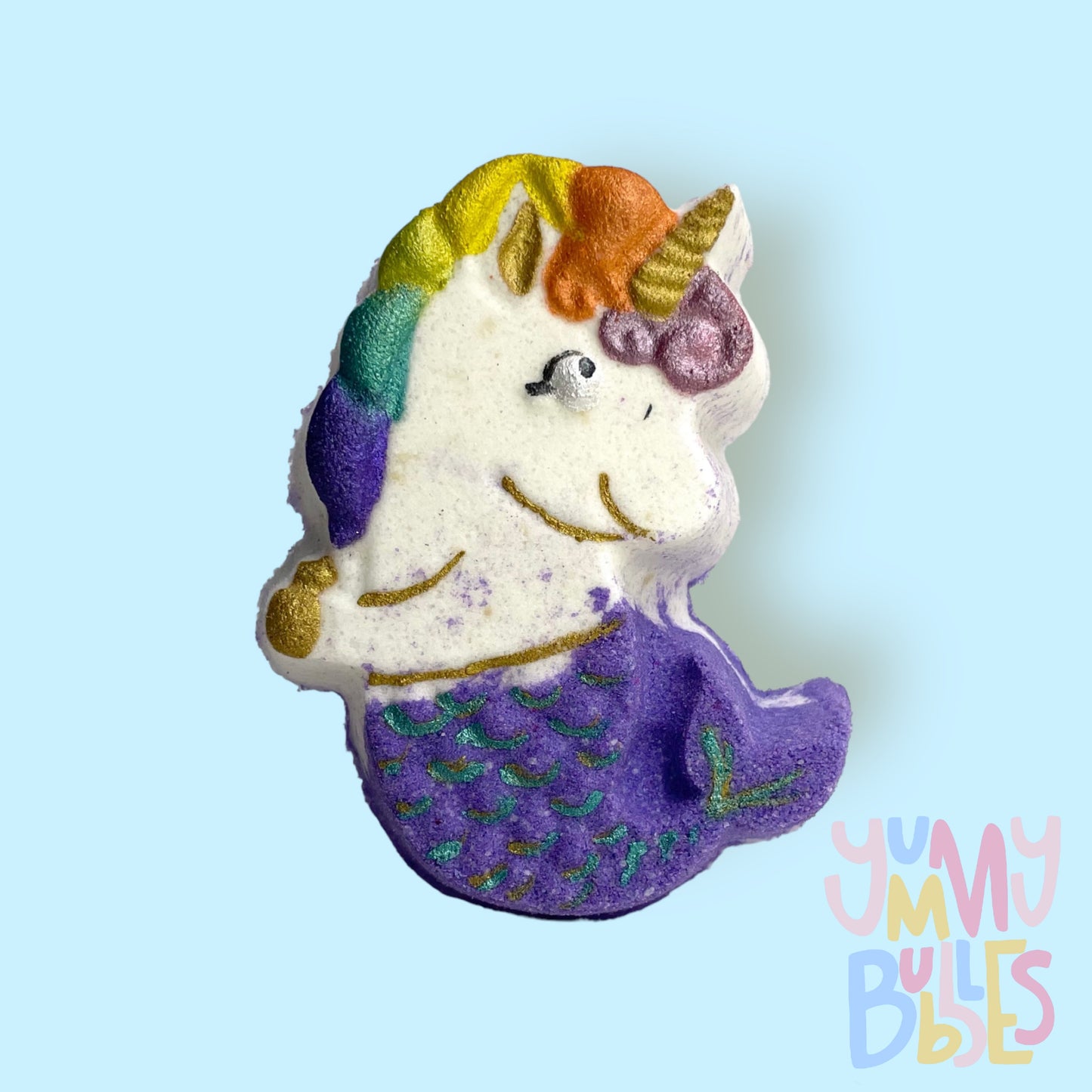 White mermaid unicorn shaped bath bomb painted with light pink, orange, yellow, teal, purple, gold, and black