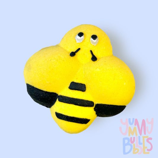 Yellow bee shaped bath bomb with black stripes and white and black eyes