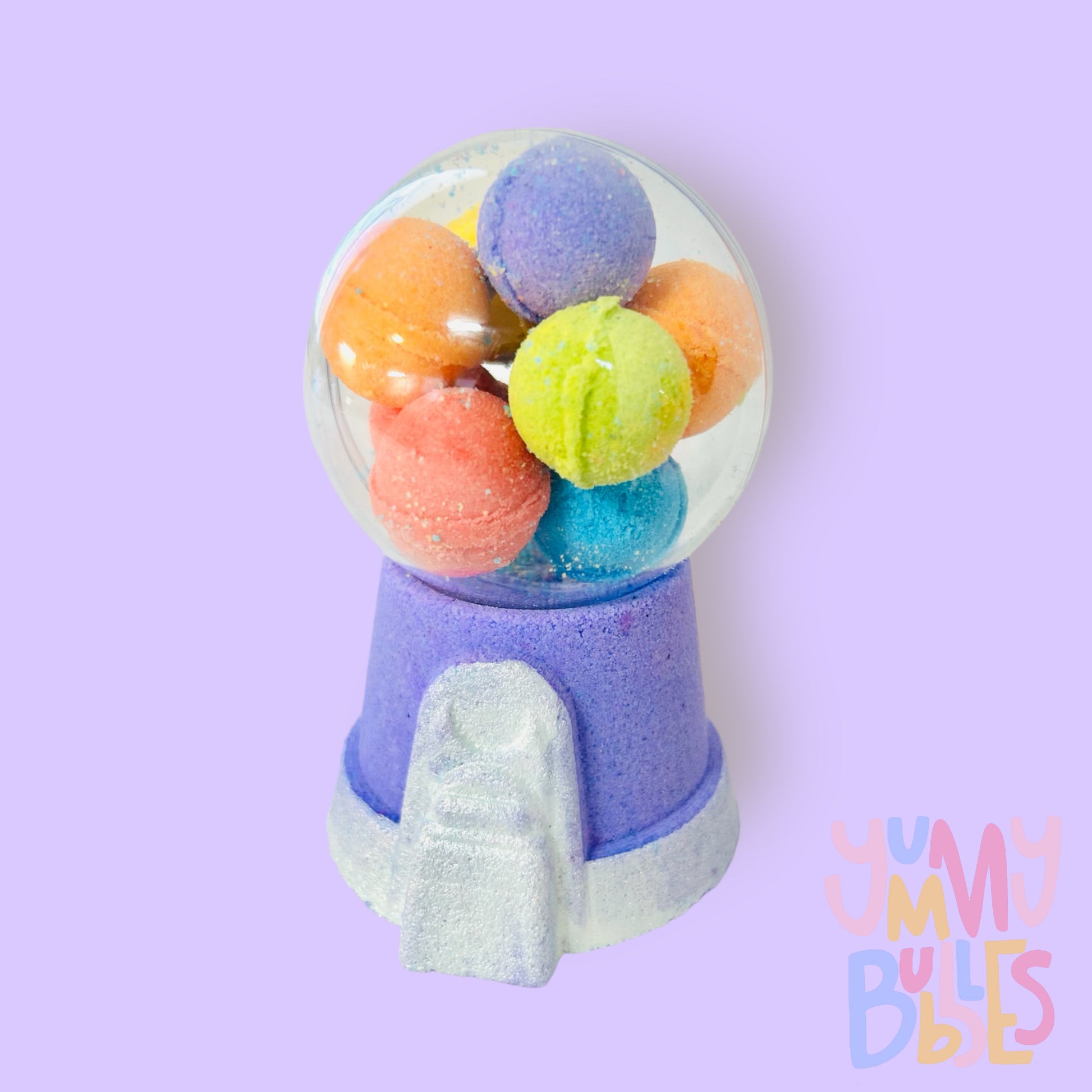 Purple gumball machine bath bomb painted with white. Contains a plastic ball on top with a variety of different colored bath bomb gumballs.
