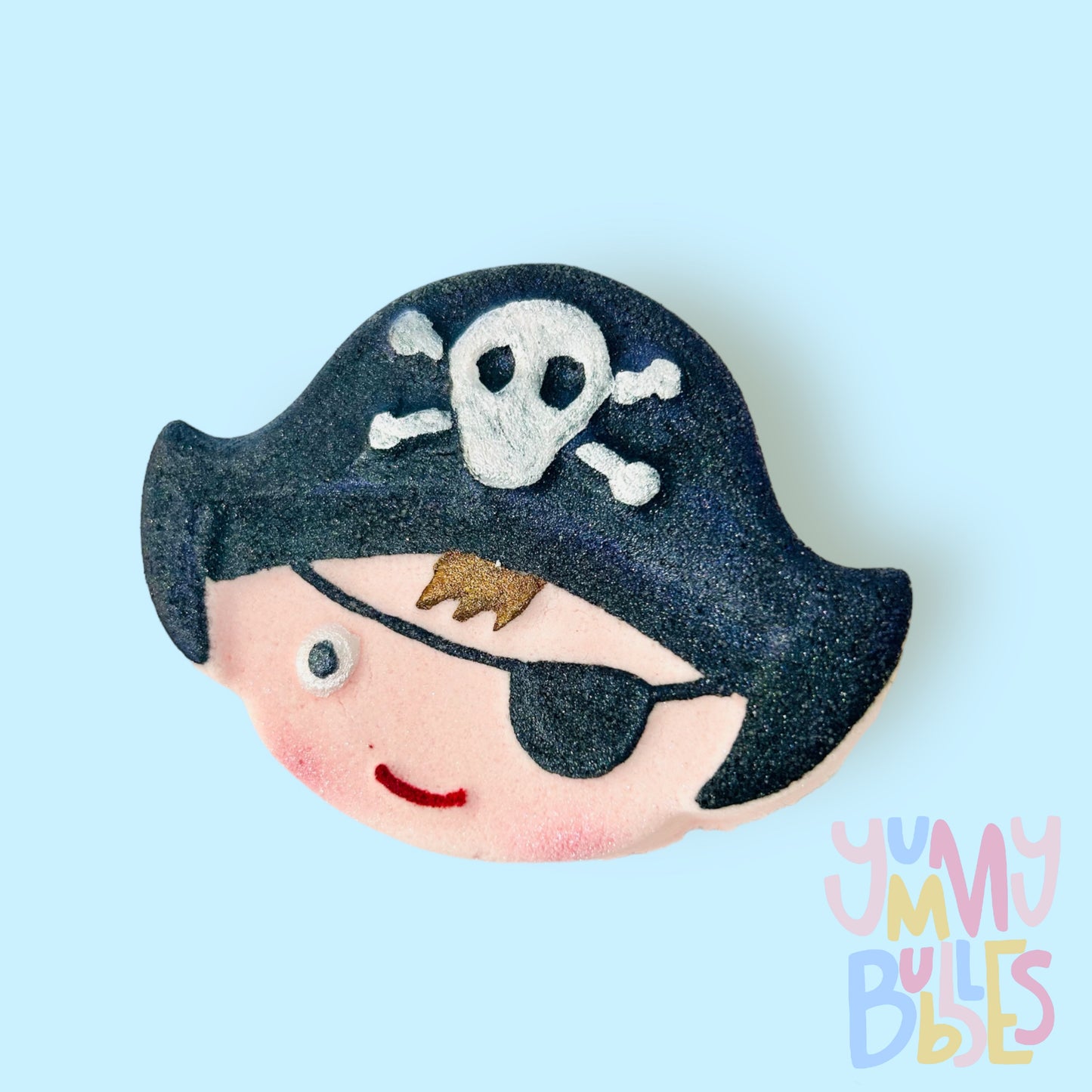 Peach pirate head shaped bath bomb with details painted in black, white, brown, and red