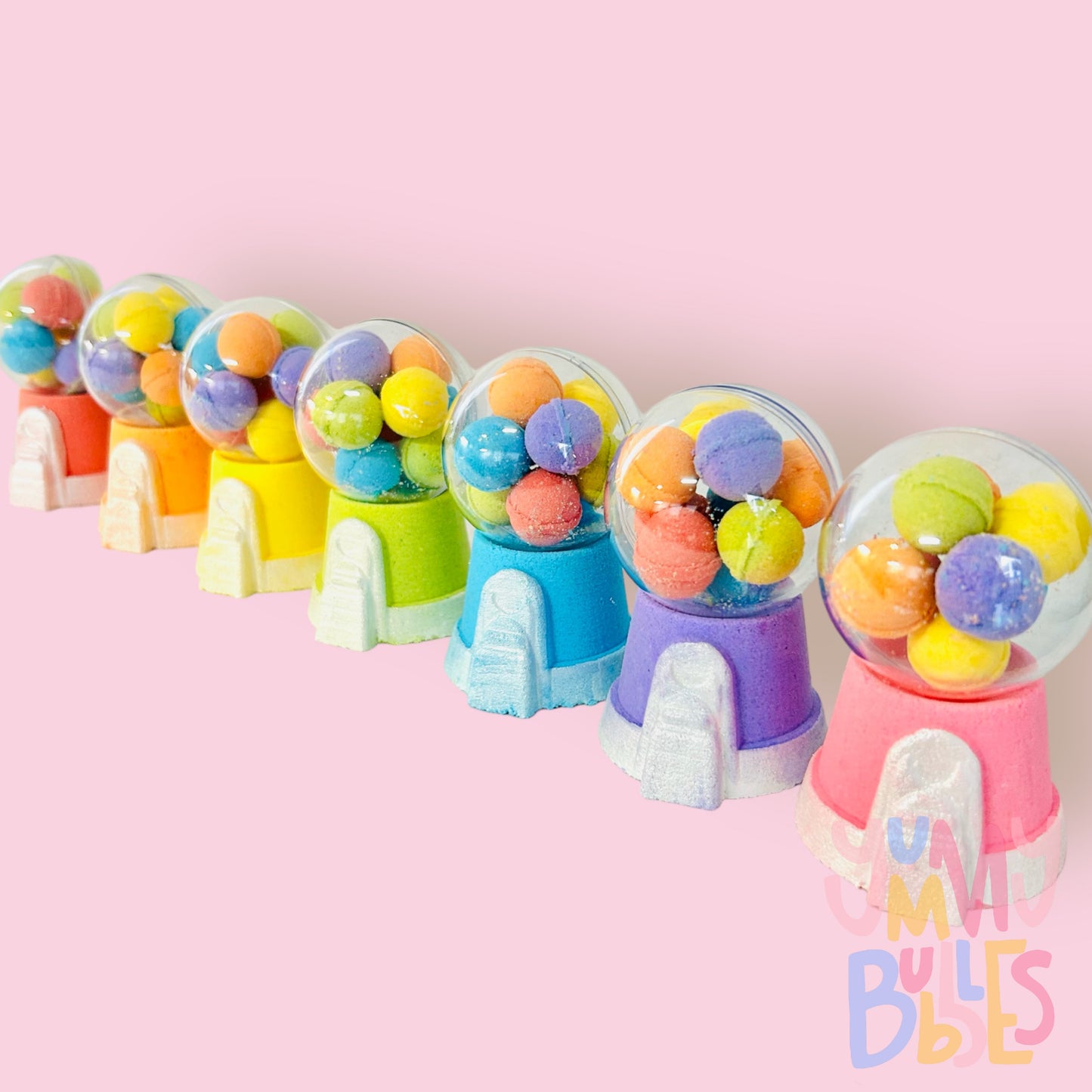 Variety of different colored gumball machine bath bombs containing a plastic ball with mini colored bath bomb gumballs.