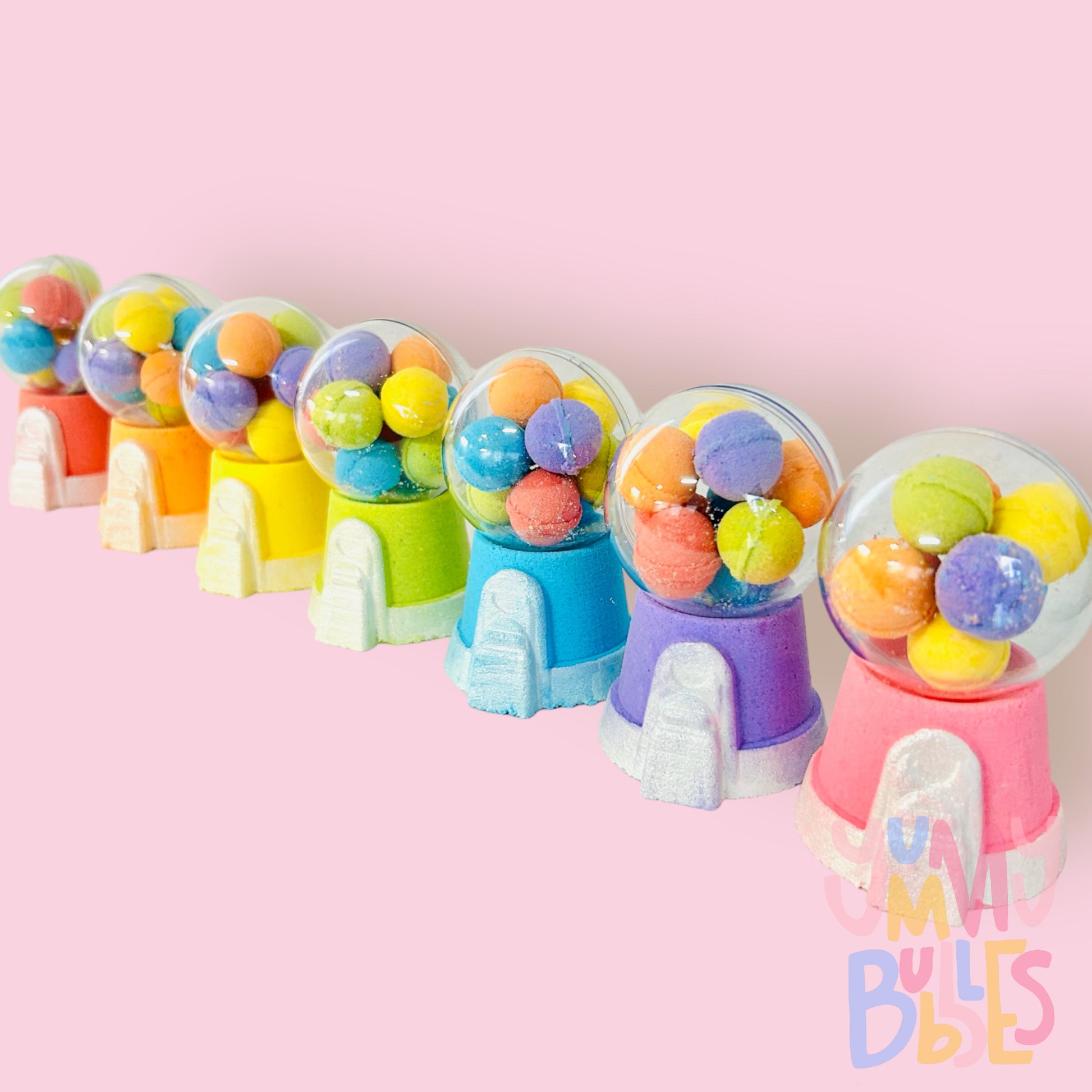 Variety of different colored gumball machine bath bombs containing a plastic ball with mini colored bath bomb gumballs.