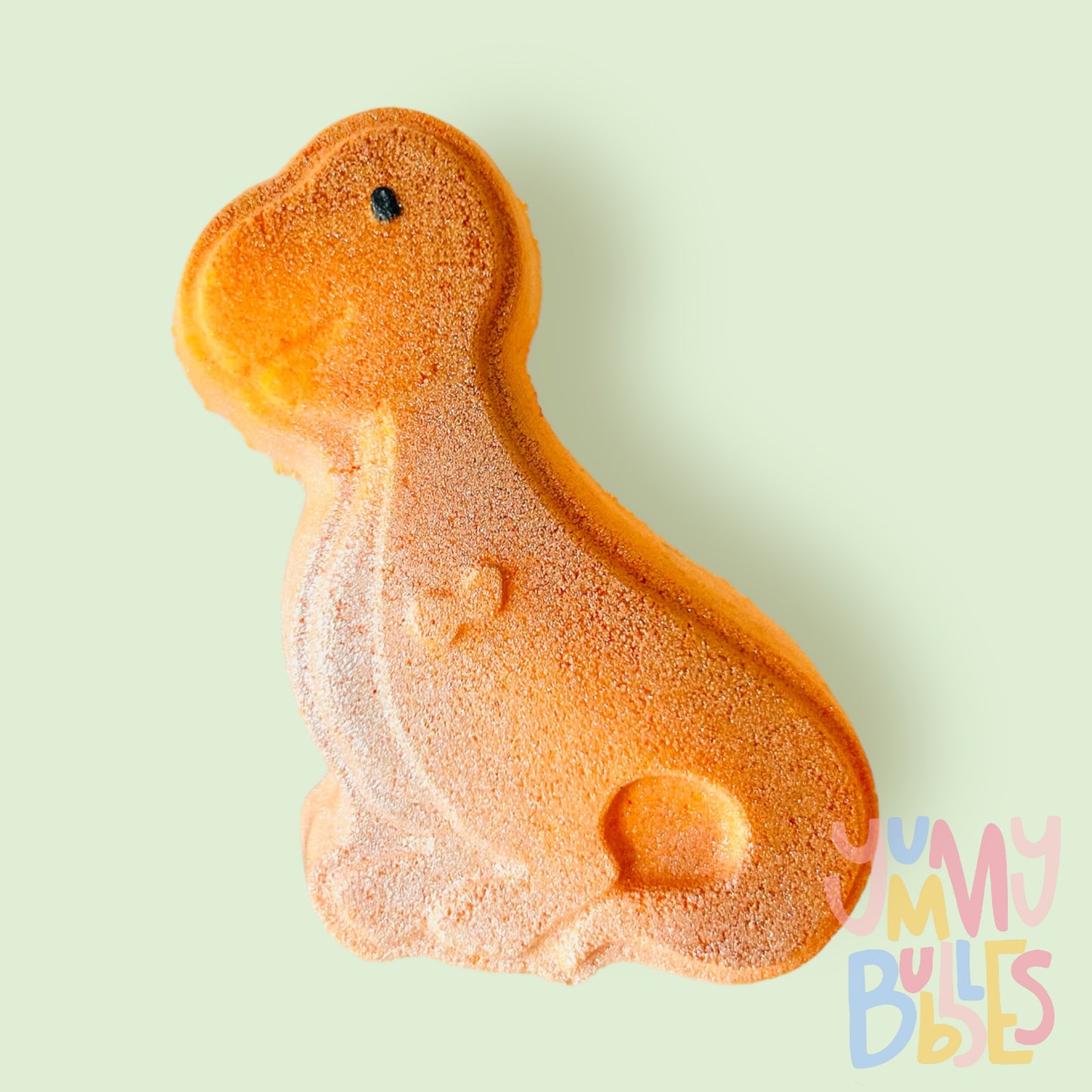 Orange t-rex shaped bath bomb with a white painted belly