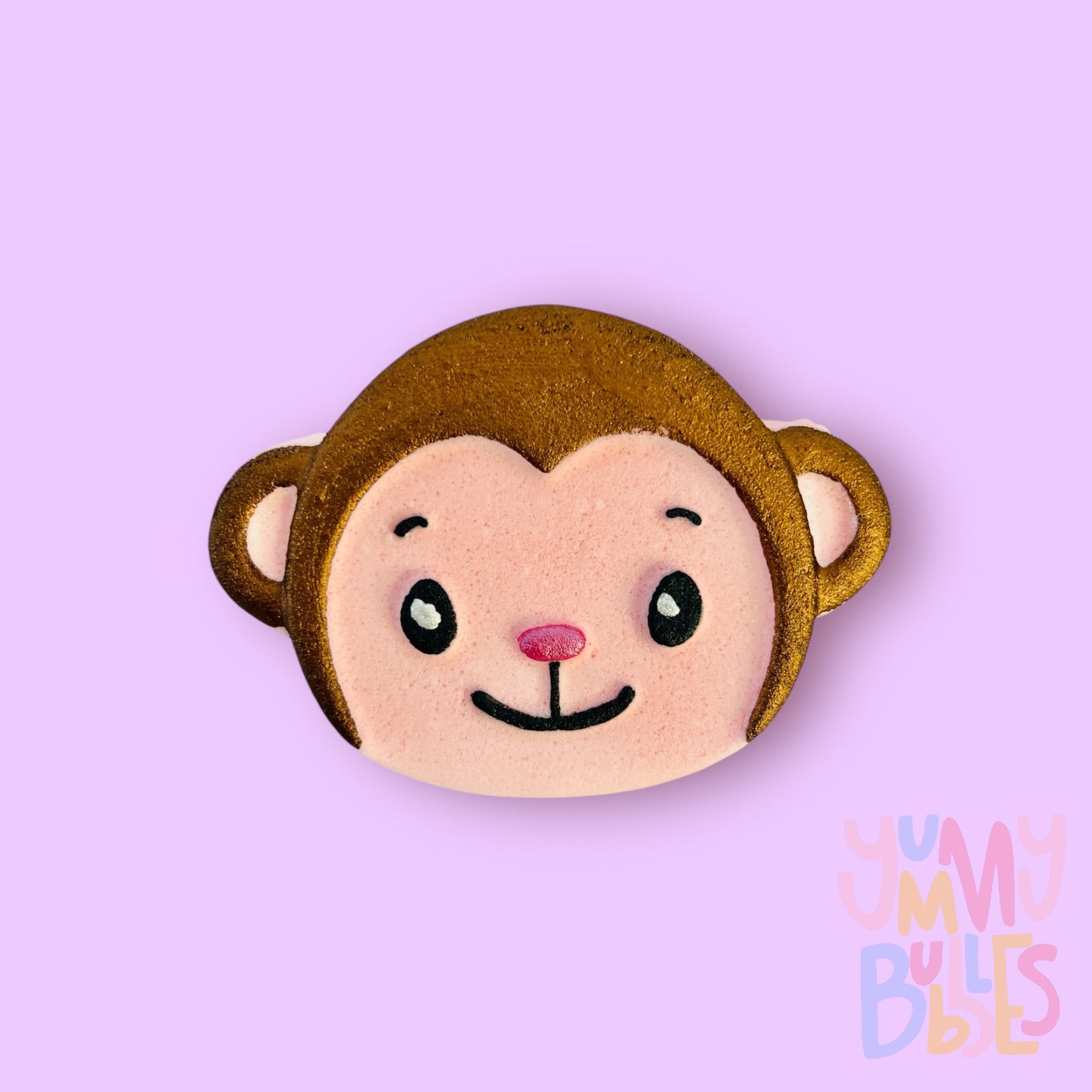 Monkey shaped bath bomb with a peach/skin colored base. Painted with brown, light pink, black and white.