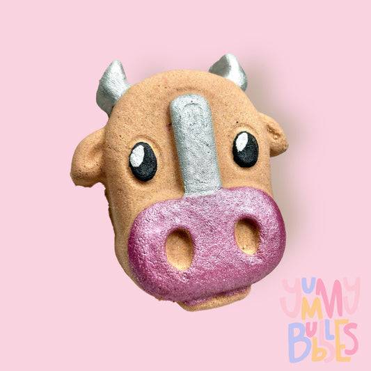 Brown cow shaped bath bomb with white, black, and light pink paint