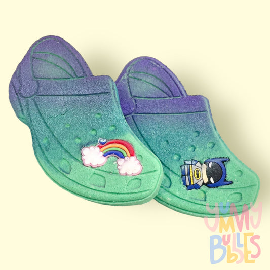 Teal croc shoe shaped bath bomb highlighted with purple paint and a croc charm on top