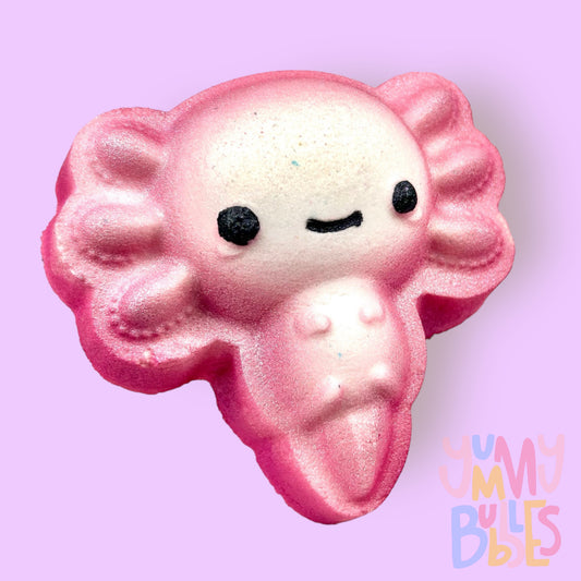 Pink and white axolotl shaped bath bomb with black painted eyes and smile