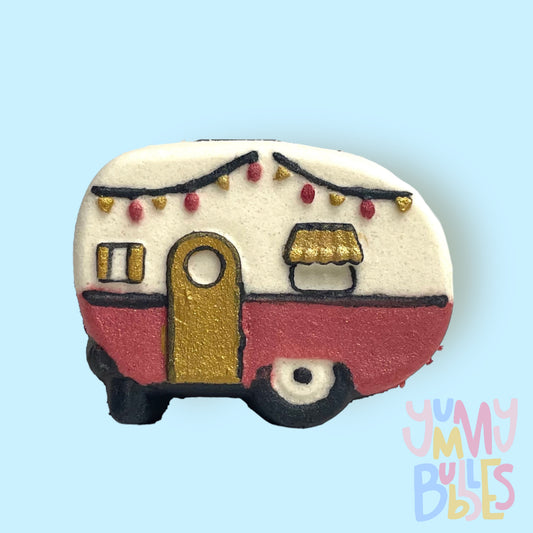 White vintage camper shaped bath bomb with black, red, and gold paint