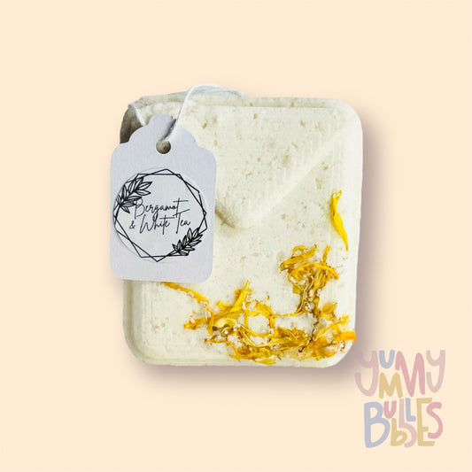 White tea bag shaped bath bomb with green tea leaves embedded on top