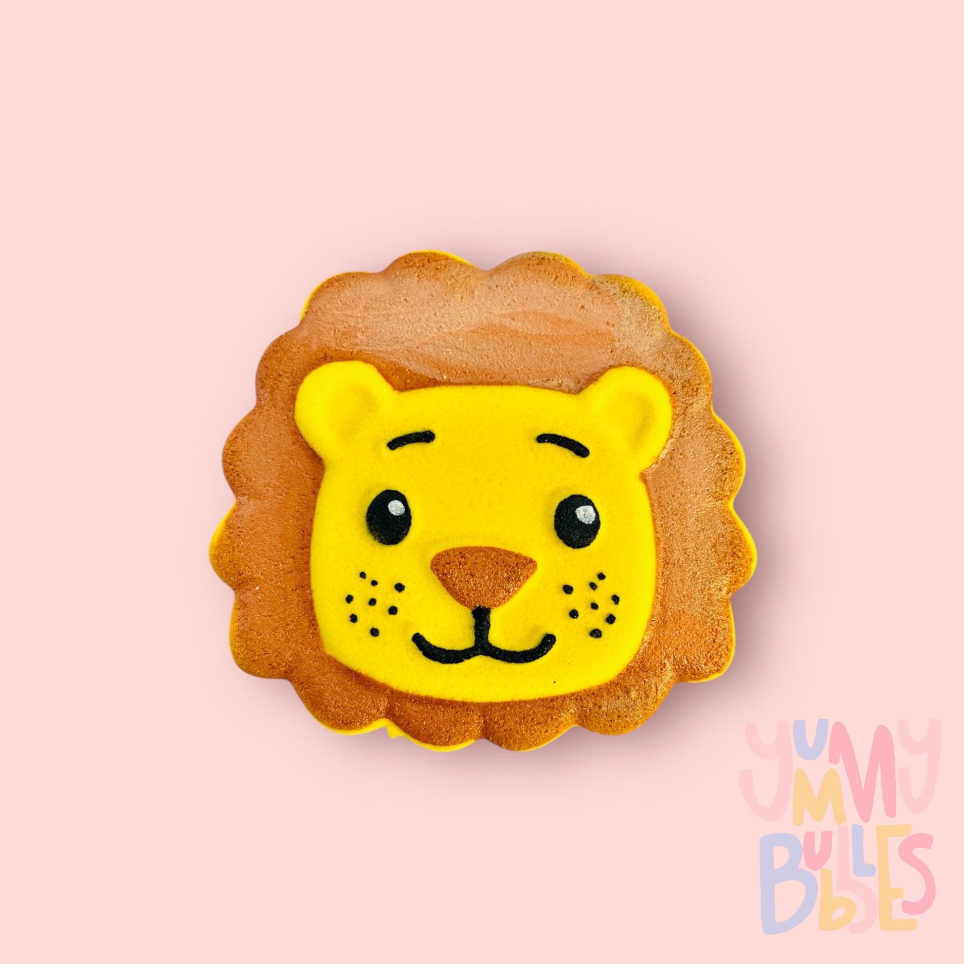 Yellow lion shaped bath bomb painted with orange, black, and white