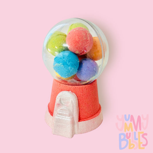 Red gumball machine bath bomb painted with white. Contains a plastic ball on top with a variety of different colored bath bomb gumballs.