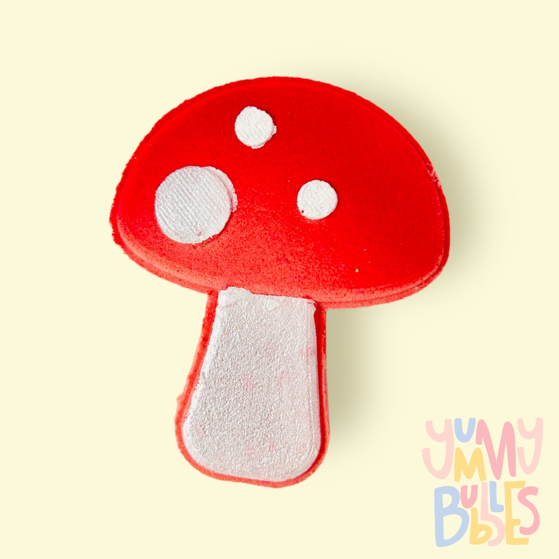 Red mushroom shaped bath bomb painted to have a white stem and white spots