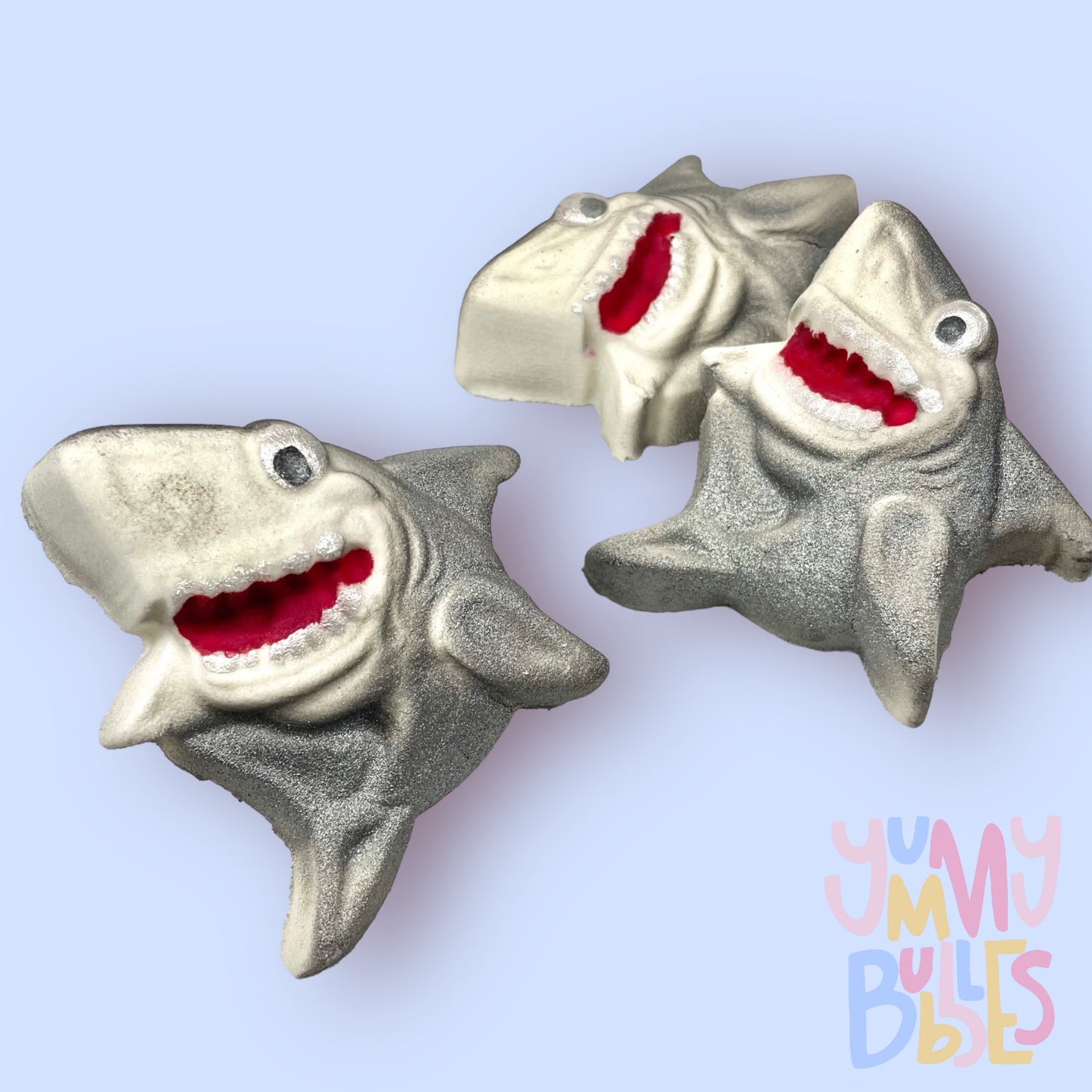 Shark shaped bath bomb painted with grey to highlight features. Mouth is painted with white and red and the eyes are painted with white and black