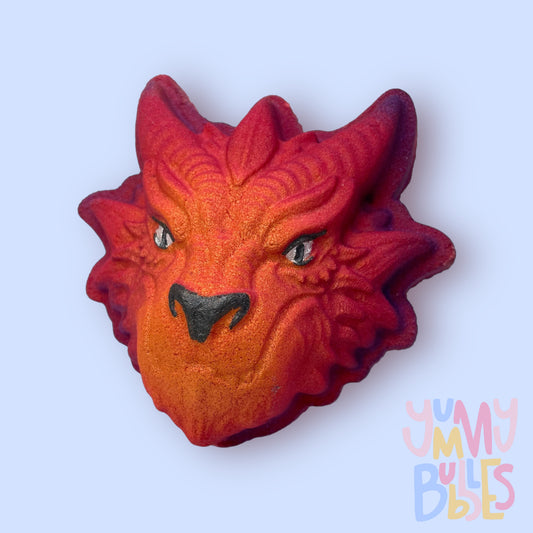 Red dragon head shaped bath bomb painted to have a purple to yellow gradient with a black nose and white and black eyes