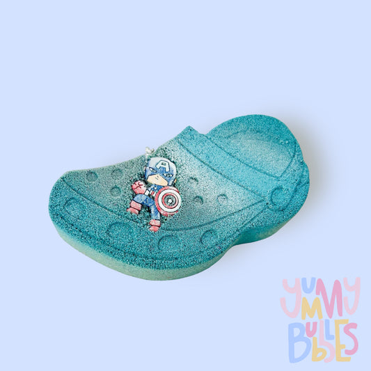 Blue croc shaped bath bomb highlighted with white paint with a croc charm on top