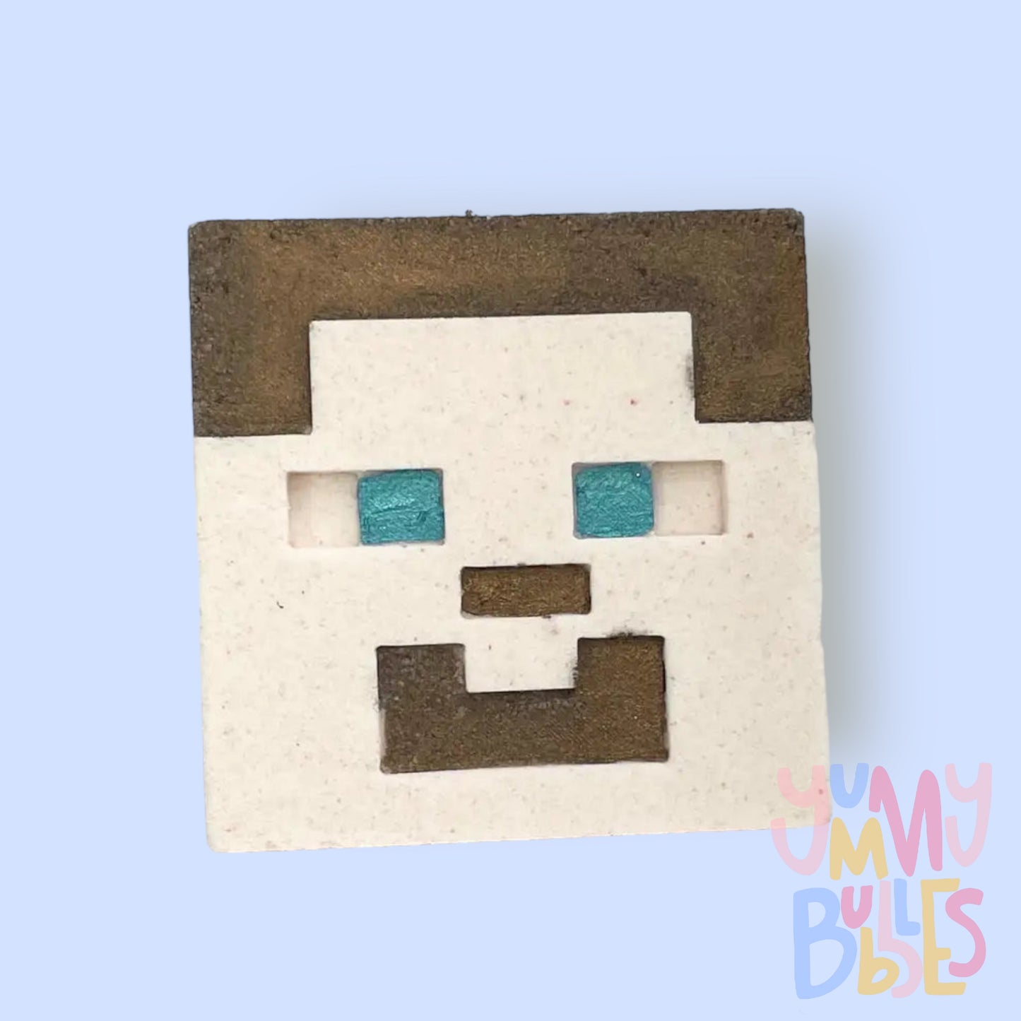 Square shaped bath bomb with Minecraft Steve's face, painted with brown and blue for facial details