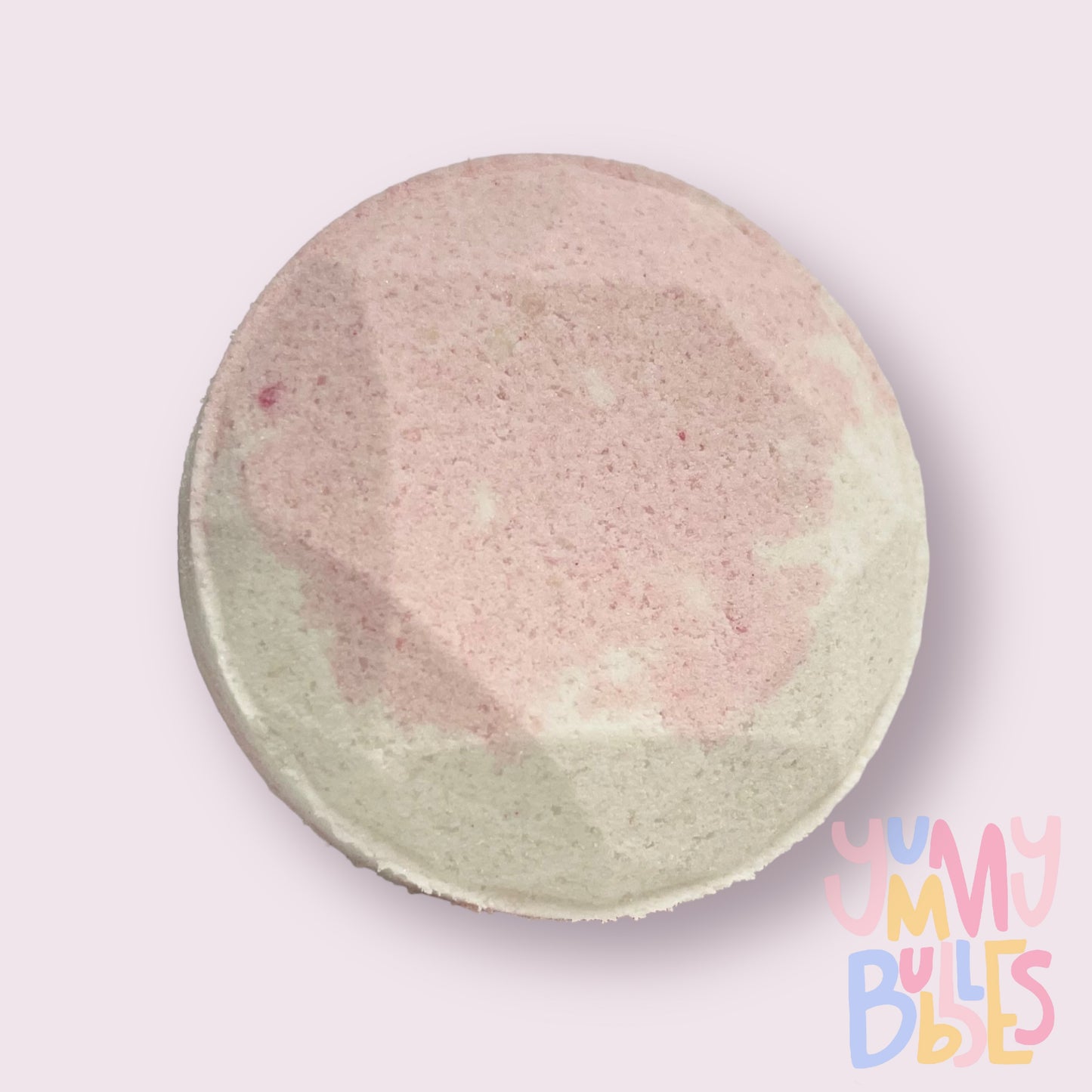 Circular shaped shower bomb colored with light pink and white