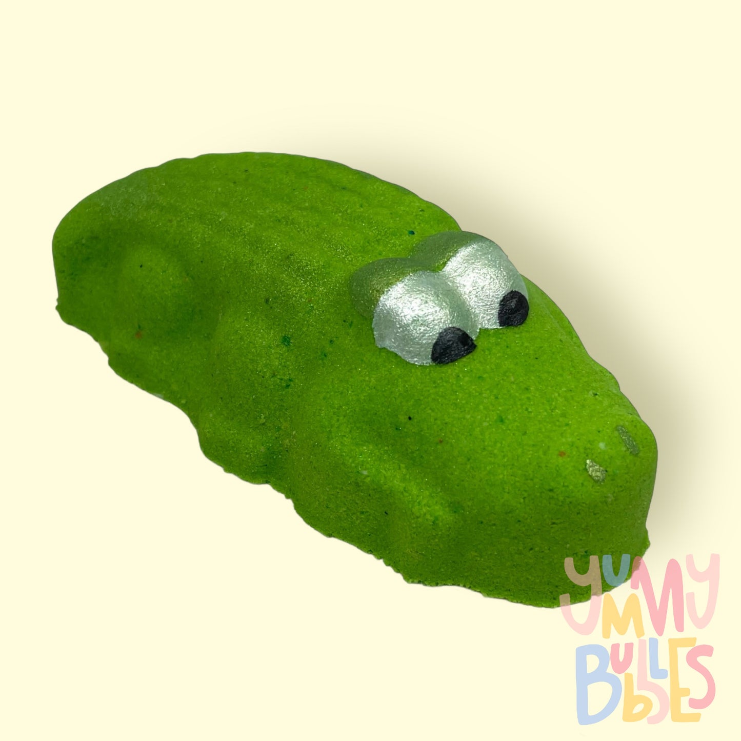 Green alligator shaped bath bomb with white and black painted eyes
