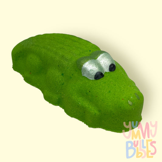 Green alligator shaped bath bomb with white and black painted eyes