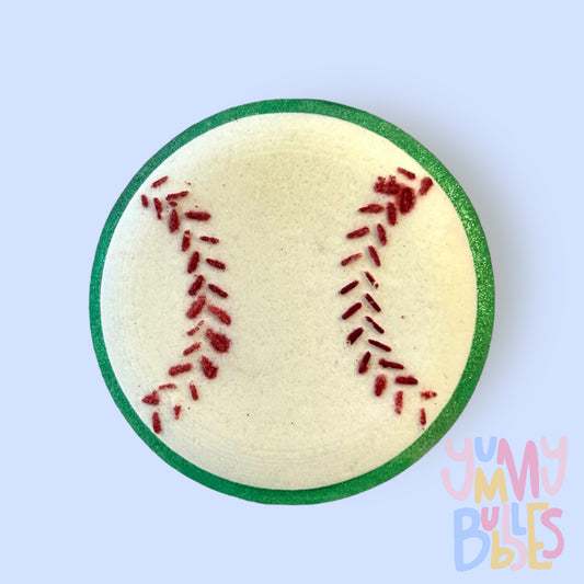 Baseball shaped bath bomb with a green base and red paint for the baseball's stitching