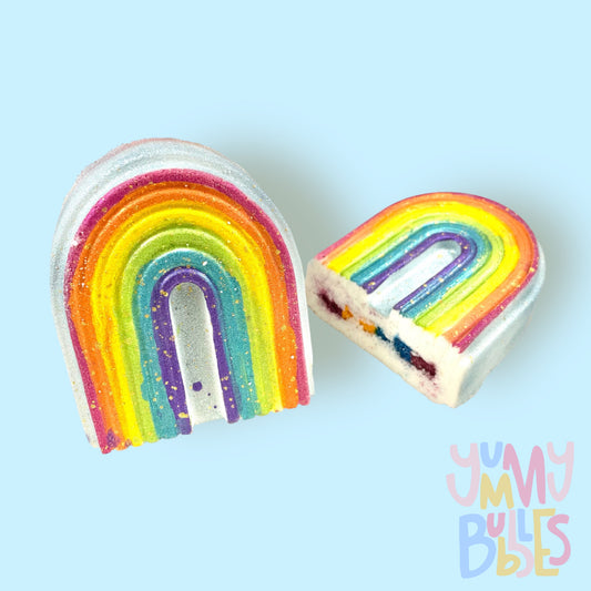 Rainbow shaped bath bomb with red, orange, yellow, green, blue, and purple paint on-top