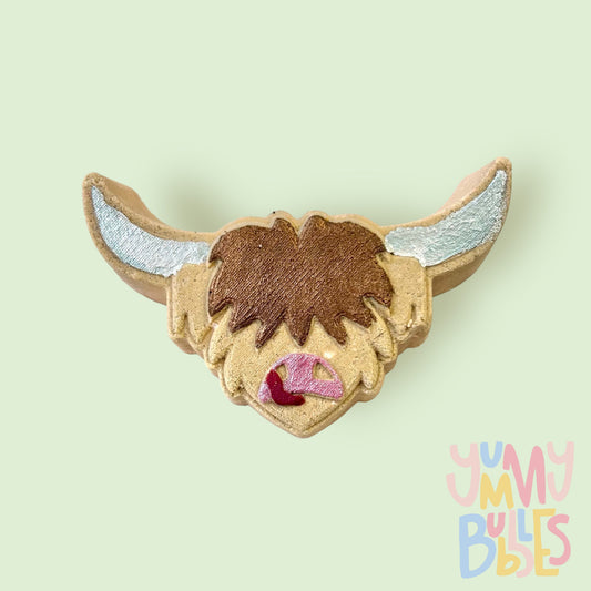 Brown highland cow head shaped bath bomb painted with white, light pink, red, and dark brown