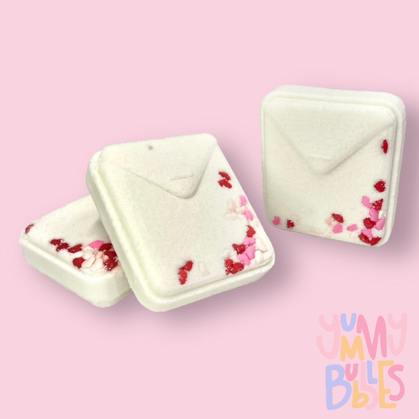 White teabag shaped bath bomb with red, white and pink heart shaped sprinkles