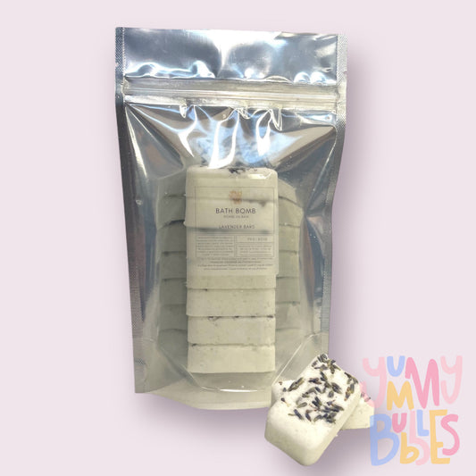 seven lavender bath bomb bars with lavender botanicals on top in a bag