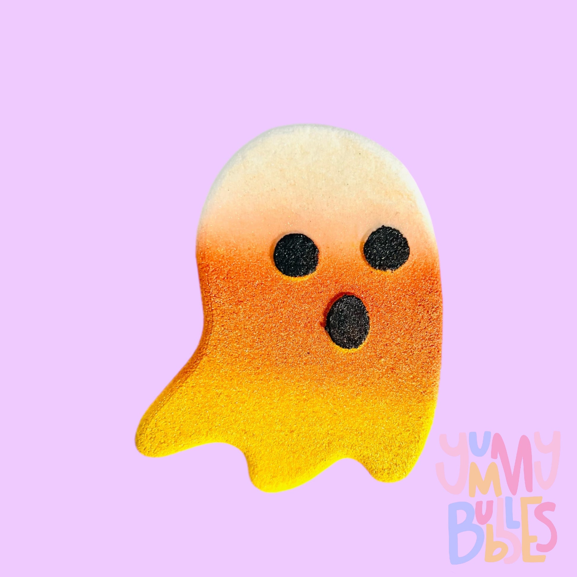 White ghost shaped bath bomb painted like a candy corn with orange and yellow with black eyes