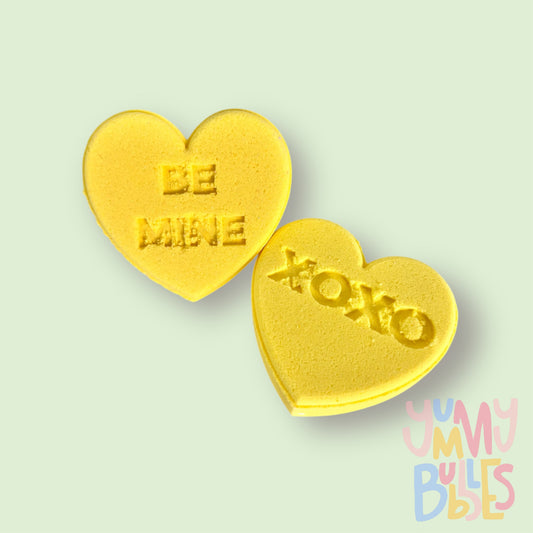 yellow candy gram shaped bath bomb with sweet messages such as xoxo, be mine, etc