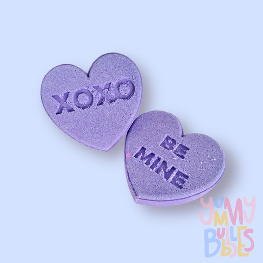 purple candy gram shaped bath bomb with sweet messages such as xoxo, be mine, etc