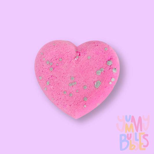 Pink heart shaped bath bomb with a white painted speckle