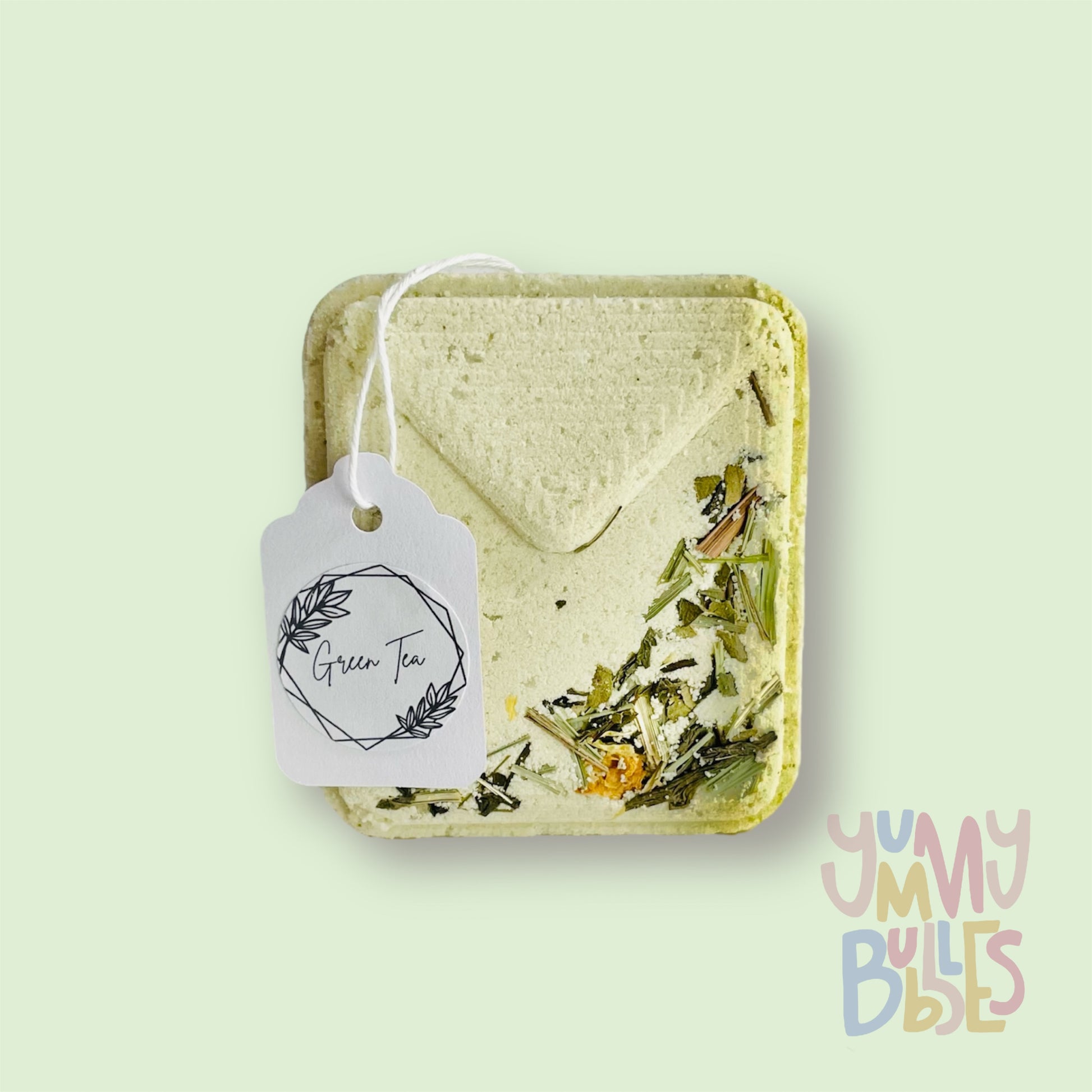 White tea bag shaped bath bomb with tea floral petals embedded on top