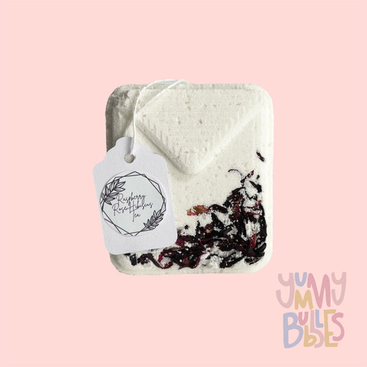White tea bag shaped bath bomb with floral petals embedded on top