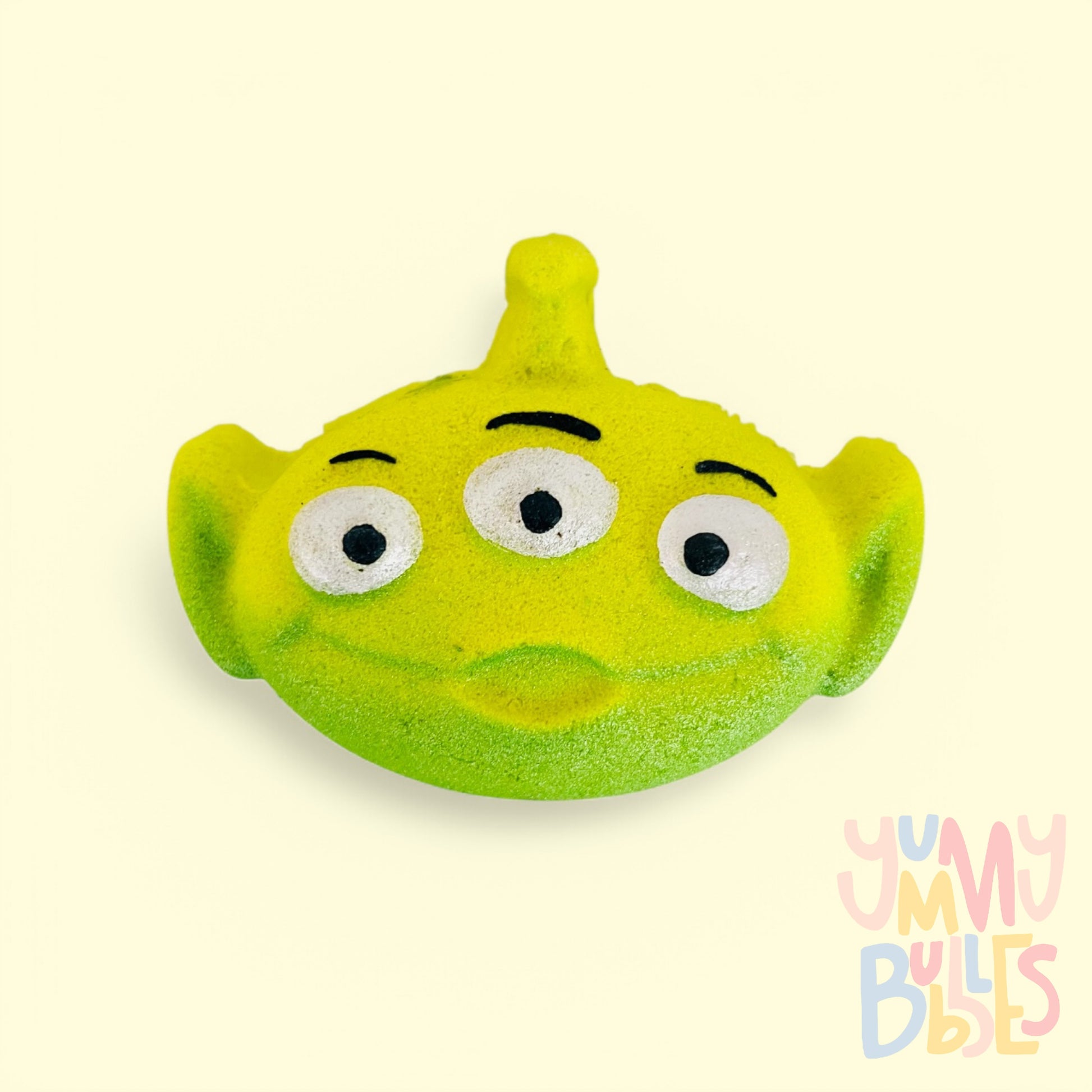 green toy story alien shaped bath bomb painted with white and black and highlighted with dark green paint