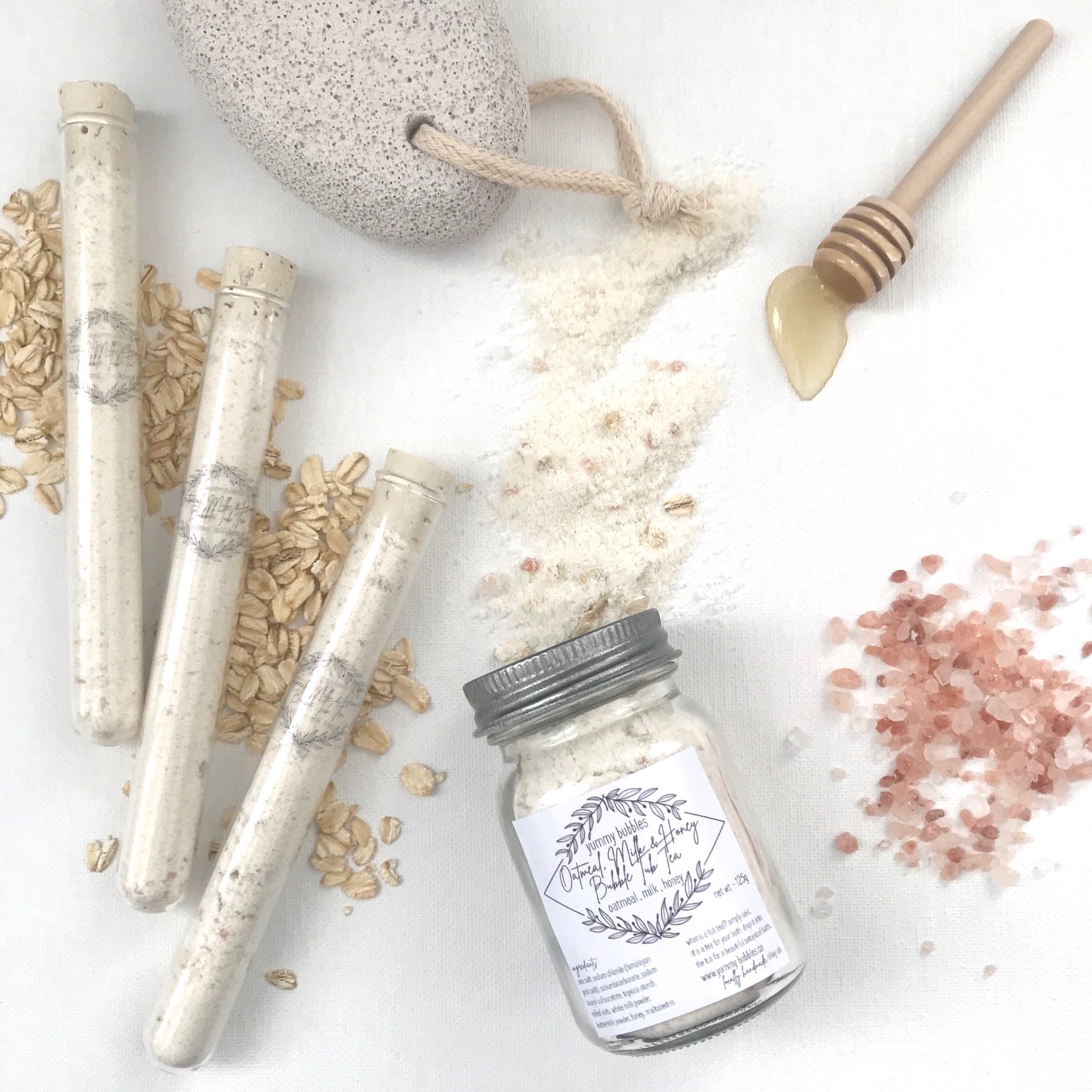 White bath bomb dust and oatmeal mixed in clear test tubes or mason jars
