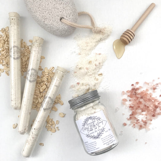 White bath bomb dust and oatmeal mixed in clear test tubes or mason jars